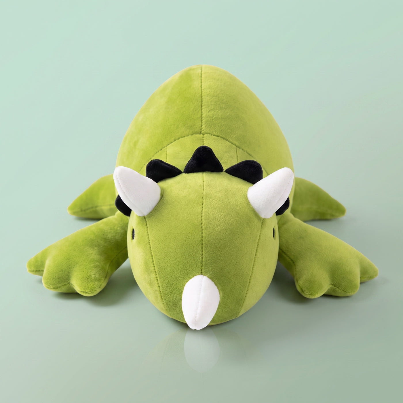 Peluche lestée Tricératops vert, fond pastel
